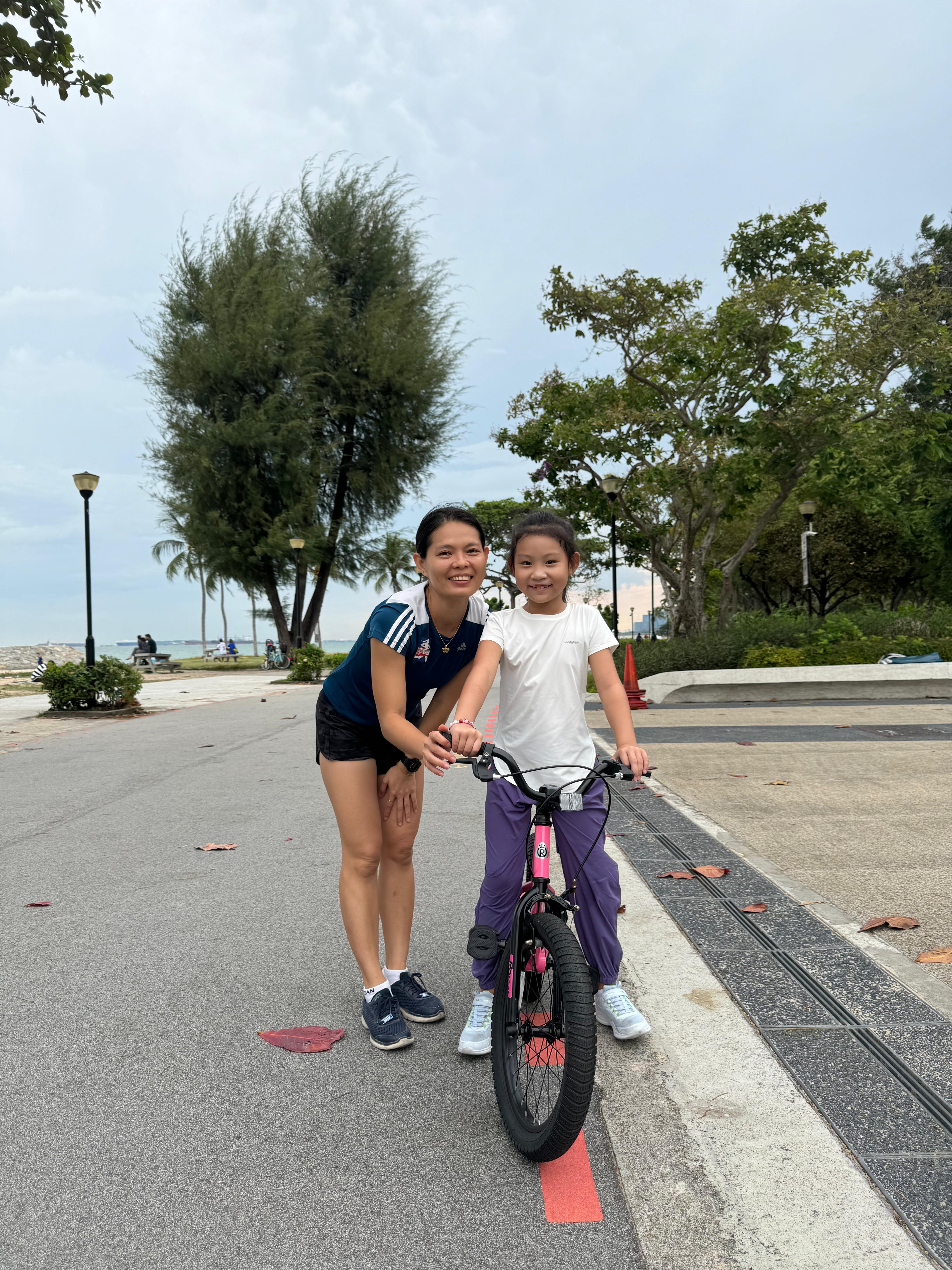 A child wearing sunglasses rides during a cycling lesson at East Coast Park